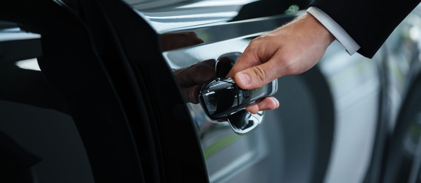 Man opening a black car door